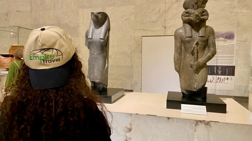 Empire Travel tourist wearing branded cap viewing ancient Egyptian statues at National Museum of Egyptian Civilization Cairo