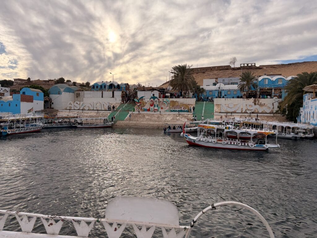 Nubian Village waterfront in Aswan with colorful houses and boats on the Nile River