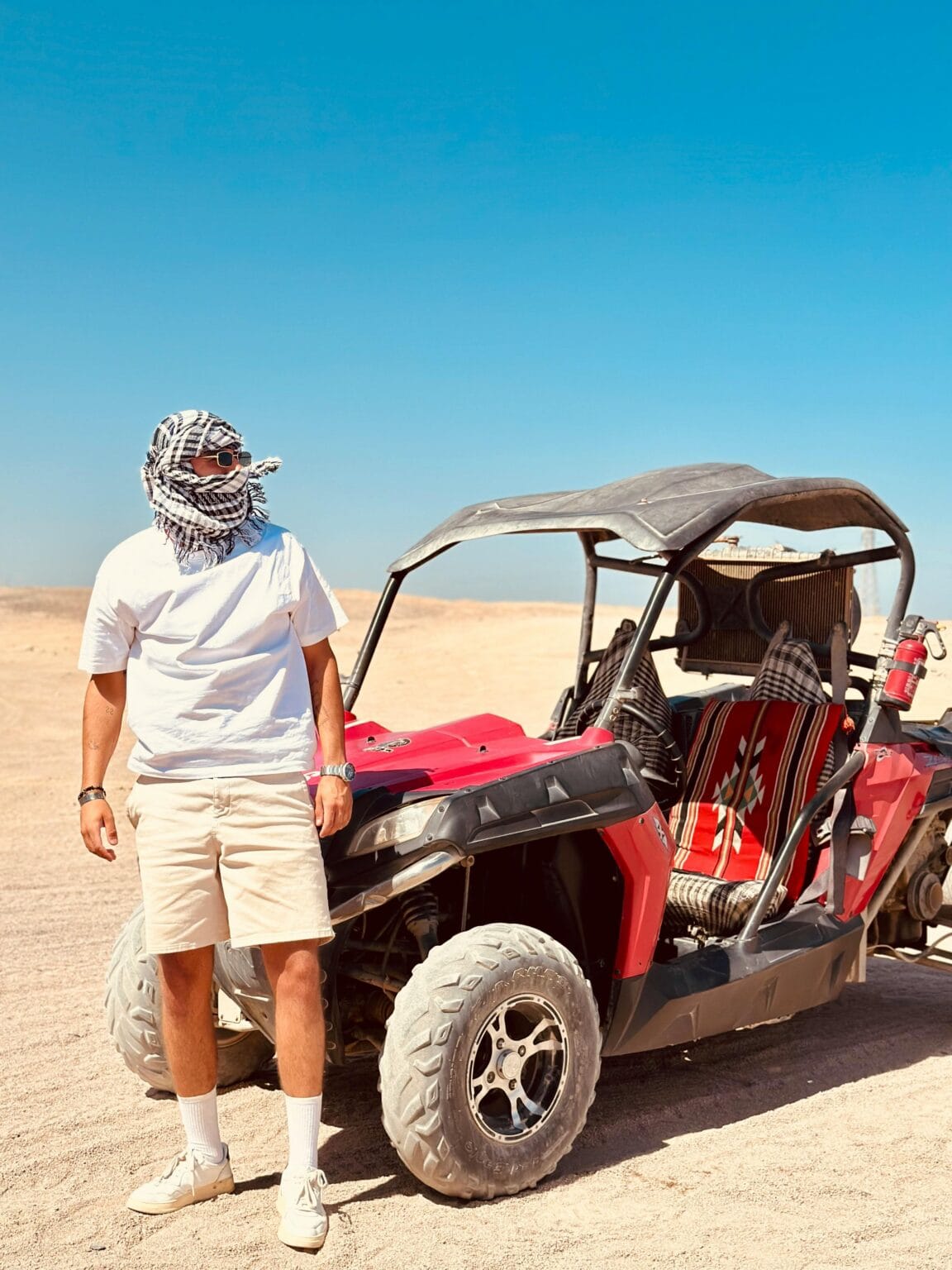 Tourist standing next to an off-road buggy during a desert safari adventure in Hurghada, Egypt.